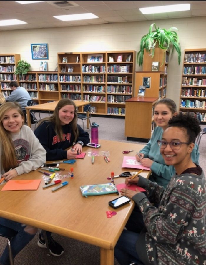 Jocelyn Wright, Savannah Weed, Lydia Walker, and Mallori Sanders make valentines for women and children. 